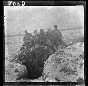 Komaika-Stellung (=Kamaja/Kamoja, Gewässer in Litauen): mehrere Soldaten in und auf einem verschneiten Laufgraben ("Gruppenbild in der Komaika-Stellung")