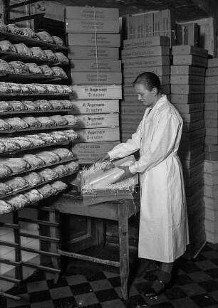 Dresden, Webergasse 35. Feinbäckerei und Conditorei Firma "Hermann Angermann", Inhaber Franz Seraph Schmid. Christstollenbäckerei. Verpacken der Inland-Versandstollen durch eine junge Mitarbeiterin