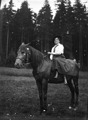 Frau im Damensitz auf einem Pferd