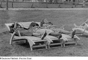 Drei Frauen, auf Liegestühlen liegend