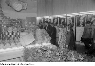 Besucher der Herbstmesse 1953 an einem Stand mit polnischen Fleischkonserven