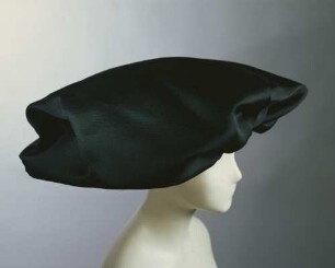 Große schwarze Haube in Form eines überdimensionierten mittelalterlichen Baretts (Archivtitel)