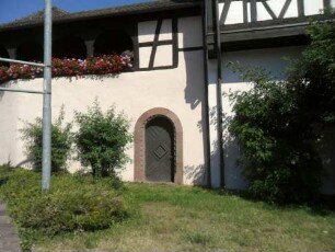 Hirsau-Kloster St Peter und Paul-Ansicht von Südsüdosten mit Klostermauer und historisierend rekonstruierter Mannpforte mit Kugelornamentik im Gewändebogen