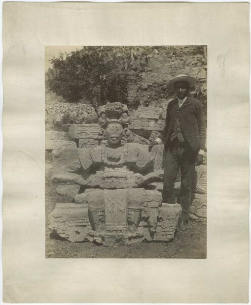 Seated figure found in the ruins of the hieroglyphic staircase. Man standing next to it.