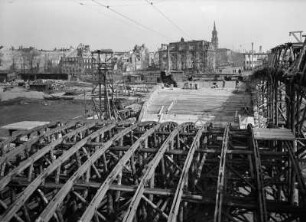 Dresden. Augustusbrücke, Wiederaufbau 1948/1949 (1907/1910; W. Kreis, H. Klette). Blick gegen Neustädter Elbufer mit Ruinen Große Meißner Straße, Blockhaus, Turm der Dreikönigskirche, Hauptstraße und Gaststätte "Narrenhäusel", rechts Notsteg