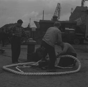 Wismar. Seehafen, Hafenarbeiter an einem Schiffstau