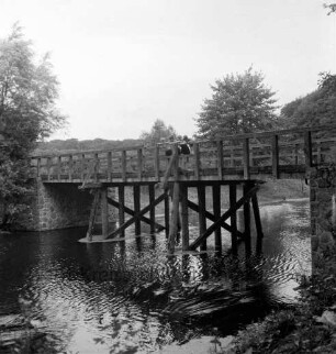 Trave: darüber Friedensbrücke: rechts oben Kinder am Geländer: hinten Bäume