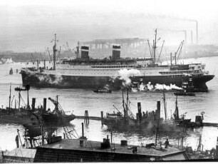 Hamburg. Hafen. Das 1932/33 in den USA gebaute Passagier-Turbinenschiff "Washington" versah 1950 regelmäßigen Liniendienst nach den USA. Hier wird das Schiff in den Hafen geschleppt. Im Vordergrund der Fischereihafen mit mehreren Fischkuttern