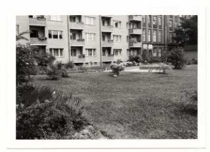 Grünflächen Wohngebiet Hansaviertel-Nord, Berlin-Tiergarten: Wohnhaus und Garten mit Sandkasten und Sitzbank in der Ferne