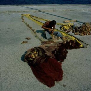 Griechenland. Insel Leros. Fischer beim Netze flicken am Hafen von Agios Marina