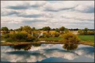 Seenlandschaft mit sich spiegelndem Wolkenhimmel