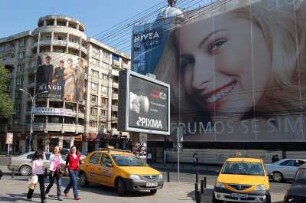 Bukarest - Verkehr im Stadtzentrum : Bukarest Zentrum, April 2007, Boulevard Dacia, mit Großwerbung verhängtes desolates ehemaliges Grand Hotel, gelbe Taxis