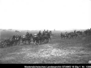 Besichtigung und Geländeübung des Feld-Artillerie-Regiments Nr. 46 Enthält: Platte 3/8, Soldaten auf einer mit Pferden bespannten Geschützlafette reiten eine Anhöhe hinauf, daneben: weitere Reiter und Zuschauer