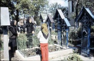 Sapinta: Der Lustige Friedhof, bemalte Kreuze, mit Personen dabei