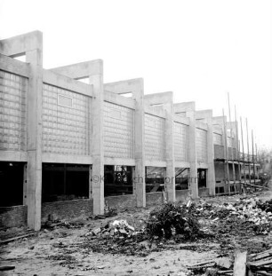 Volksschule: Sporthalle: Rohbau: vorn und innen Baumaterial: hinten Gerüste