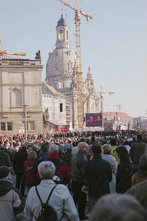 Frauenkirche : Besucher des Weihegottesdienstes stehen vor der Großleinwand auf dem Parkplatz zwischen Kulturpalast und Johanneum und auf dem Neumarkt