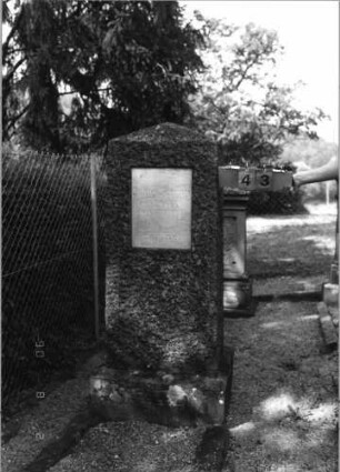 Grabstein 43 (Index: 99793145) Material: schwarzer, unpolierter Granit, Schriftplatte Marmor Maße HxBxT: 164x54x39 cm Beschreibung: Stele mit Walmdachabschluß, rechteckige Schriftplatte eingelassen, Sockel, Grabeinfassung: Grabstein 43
