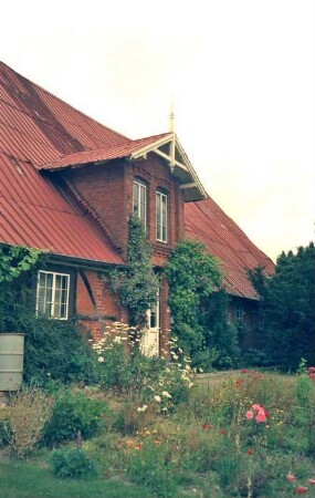 Fliegenfelde 9: Bauernhaus, Fachwerkbau: Traufseite: Teilansicht: links Wohntrakt, über Eingangstür Zwerchgiebel, rechts Wirtschaftstrakt