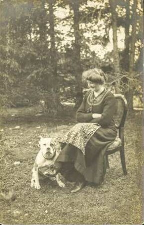 [Sitzende Frau neben einem Hund]
