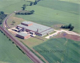 Akro Plastic GmbH & Co. KG (Kornkamp 50): Luftbild des Betriebes: links Bahnstrecke Hamburg-Lübeck mit dem abzweigenden Industriegleis