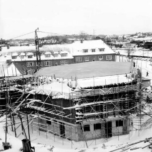 Erweiterungsbau [später Gebäude C] mit Kreistagssitzungssaal: IV. Bauabschnitt: Kreistagssitzungssaal mit Bedachung und Gerüst: links Rohbau des Erweiterungsbaus: hinten links Baukran: dahinter Wohnblock an Reimer-Hansen-Straße: hinten rechts Bahngleise und Güterschuppen: Winter