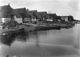 Fischerhäuser : Häuser mit Reetdächern im Dorf Kepa (Kamp). Am Ufer kleine Boote