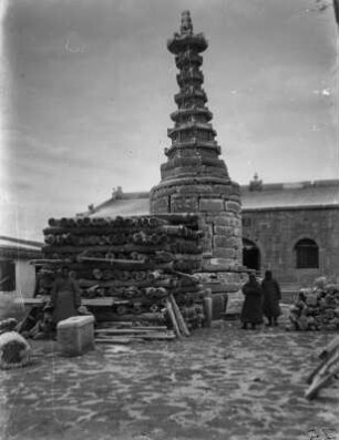Stupa : Holzscheite vor einem einfachen Stupa(?)