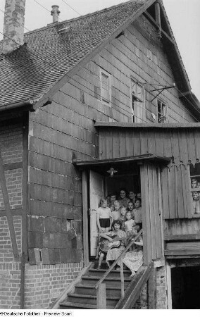 Kinder beim Singen mit Betreuerin im Hauseingang der Alten Winkelmühle