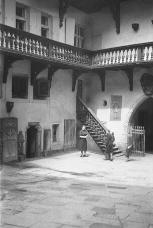 Innenhof : Ein Innenhof eines historischen Gebäudes. Zwei Personen befinden sich vor einer Treppe.