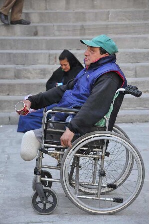 Barcelona - Behinderter im Rollstuhl bettelt : Vor der Kathedrale sitzt ein behinderter Mann in seinem Rollstuhl und bettelt Passanten an. Aufgenommen am 15. April 2012 in Barcelona