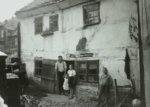 Güstrow. Fachwerkhaus der inneren Altstadt. Vater mit drei Kindern vor der Hoftür
