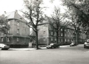 Dresden-Trachau. Wohnsiedlung des Bauvereins Kleinwohnungsbau (1919/1921; O. Schubert). Wohnanlage mit Torbogen, Wilder-Mann-Straße 21 d/Kopernikusstraße 15/21. Eckansicht mit Einfriedung