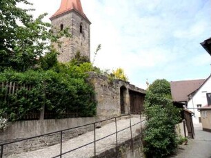 Ansicht von Südosten mit Kirchturm (spätromanisch) über Zwingermauer (Wehrgang im 19 Jh abgetragen) aus dem Ort mit neuzeitlicher Zugangspforte