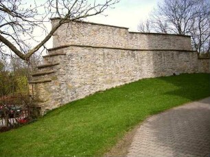 Kirchhof im Norden-erhaltener (und restaurierter) Abschnitt der -festen- Kirchhofmauer mit Steinbrüstung des Wehrgangs (mit Schießscharten) - hölzerner Laufgang und Regendach nicht ergänzt