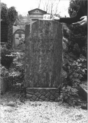 Grabstein 44 (Index: 99805041) Material: geschliffener Granit ?? Zustand: aufgesetzte Buchstaben fehlen Maße HxBxT: 124x60x20 cm Beschreibung: Stele auf Rusticasockel: Grabstein 44
