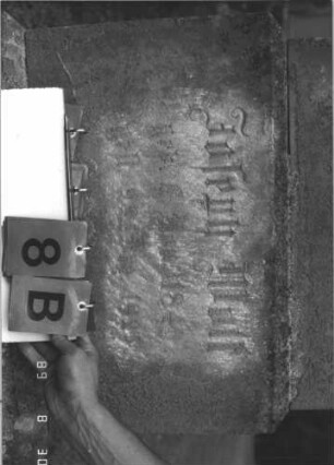Grabstein 8 (Index: 99609644) Material: Sandstein Zustand: stark verwittert, weitgehender Textverlust Maße HxBxT: 203x56x24 cm Beschreibung: obeliskenartige Stele, getreppter Sockel Symbolik: segnende Hände: Grabstein 8B