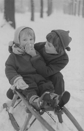 Kinder beim Ski- und Schlittenfahren, zwei Jungen mit Schlitten