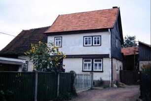 kleines Gehöft mit verschiefertem Giebel am Wohnhaus; Garten und Sonnenblumen