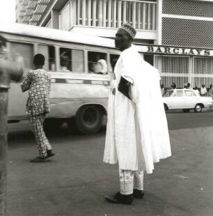 Lagos, Nigeria. Straßenszene im modernen Stadtzentrum mit Nigerianer in Festtracht