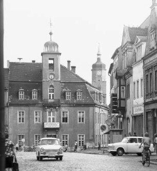 Markt in Wurzen : Wurzen. Blick über den Marktplatz zum Rathaus hin, an dem am Balkon unter dem Uhrenturm ein Banner hängt mit der Aufschrift: „Mit neuen schöpferischen Ideen und Taten, mit Herz und Verstand bereiten wir den 30. Jahrestag unserer Republik vor“