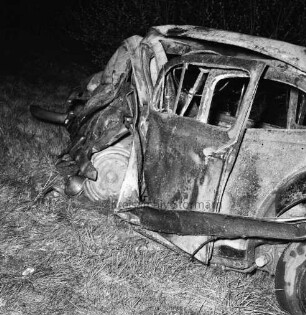 B 404: bei Herrenhaus Nütschau: Verkehrsunfall: Zusammenstoß von zwei Pkws und Auffahrunfall: auf Wiese ausgebrannter Unfallwagen nach Löschen: im Dunkeln, 1. Mai 1967