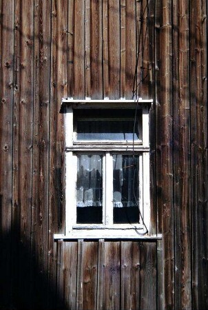 Fenster in einer verbretterten Fassade