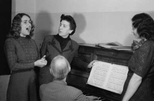 Aufnahmen der Opernsängerin Frida Leider, Leiterin des Gesangsstudios der Staatsoper Berlin, beim Gesangsunterricht mit ihren Schülern : Frida Leider (2. von links) beim Unterricht mit zwei Schülern