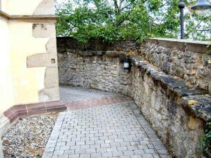 Kirchhof im Osten - Kirchhofmauer mit Konsolsteinen sowie Steinbrüstung des Wehrgangs mit Werksteinen im Mauersteinverband