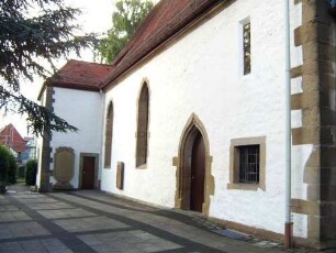 Langhaus (Spätgotischer Neubau auf Vorgänger-Überarbeitung 1848) über Traufseite Nord mit spitzbogigem Portal sowie Sakristei im Osten am Chor in Übersicht
