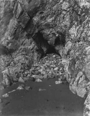 Höhle : Felswand am Strand mit einer kleinen Höhle