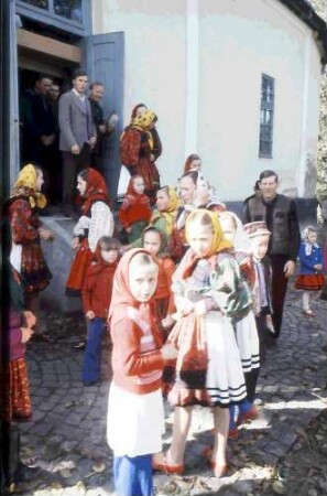 Huta Certeze: Trachtengruppen, Frauen und Kinder vor der Kirche