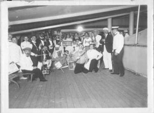Hochseepassagierdampfer Cleveland, Bordaufnahmen. Gruppenbild mit kostümierten Touristen und Katzen in Tierkäfigen während eines Bordfestes