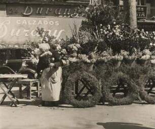 Barcelona. Spanien. Blumenverkäuferin auf der Rambla de las Flores vor ihrem Stand