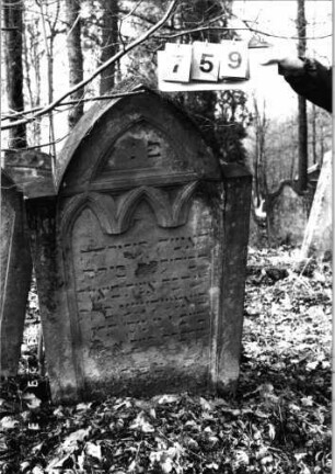 Grabstein 759 (Index: 99751592) Material: Sandstein Zustand: abgeblättert mit Textverlust Maße HxBxT: 125x69x13 cm Beschreibung: Stele, eingezogener Spitzbogenabschluß, Schriftfeld eingetieft Symbolik: Spitzbogenfries: Grabstein 759